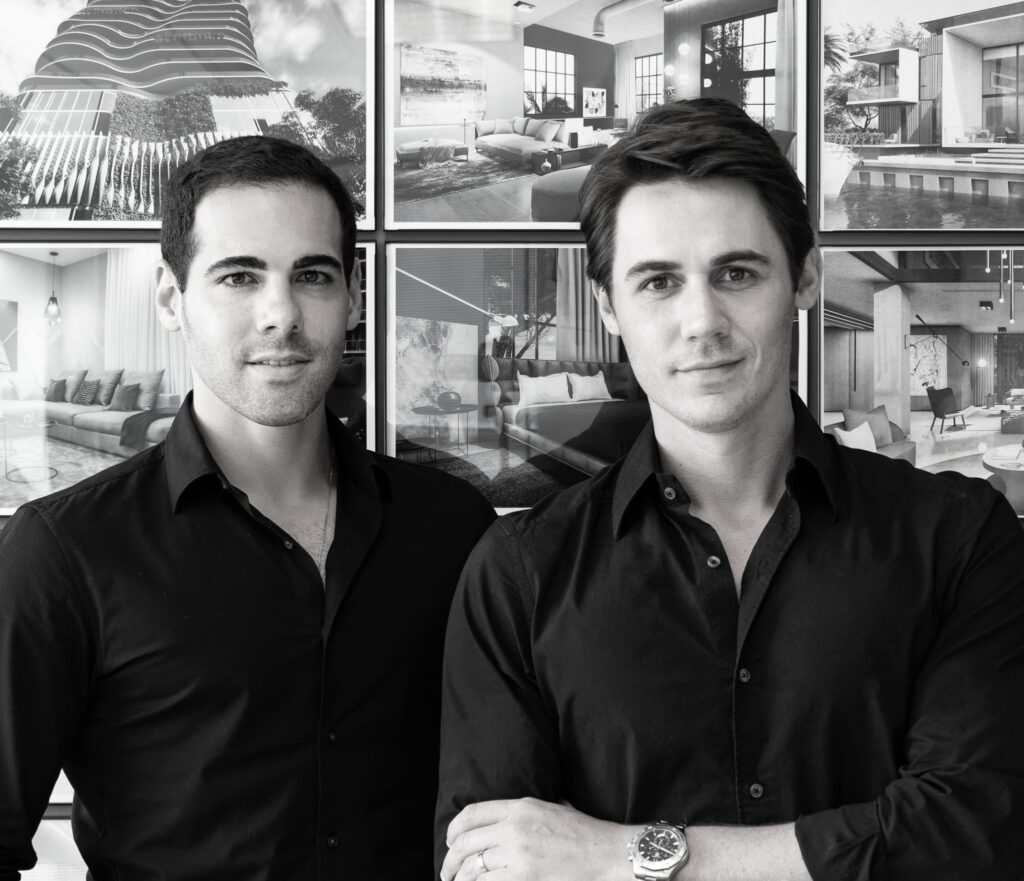 Picture of Miami Interior Designers Nicholas Gennari and Roberto Racy in black and white effect, wearing black shirts, background showing hanging pictures with examples of Interior Design Miami projects.