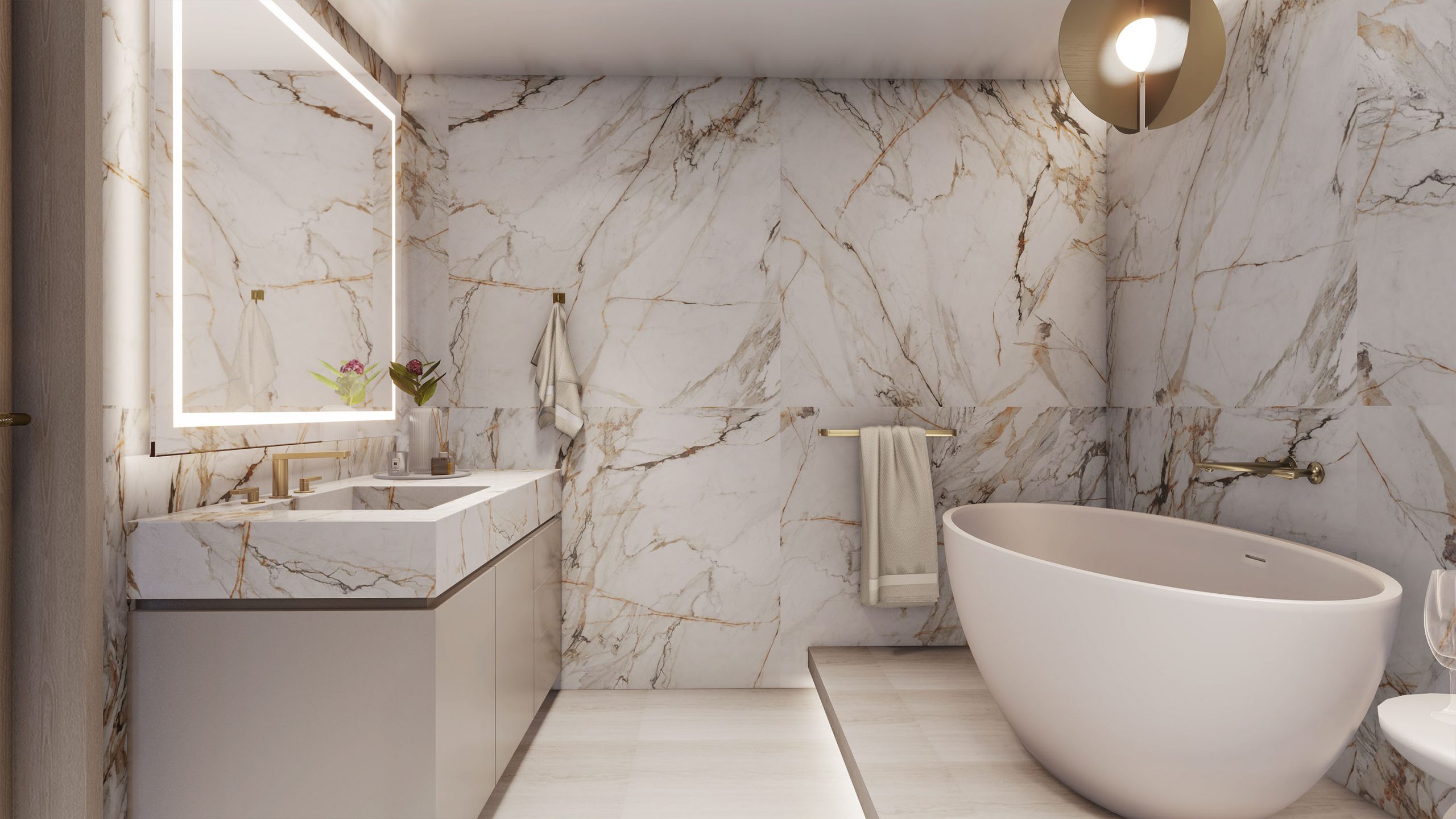 Stylish bathroom in like colors with travertine floor and busy white marble walls with golden veins, white countertop, large mirror, freestanding bathtub, gold light fixtures and frosted glass shower enclosure