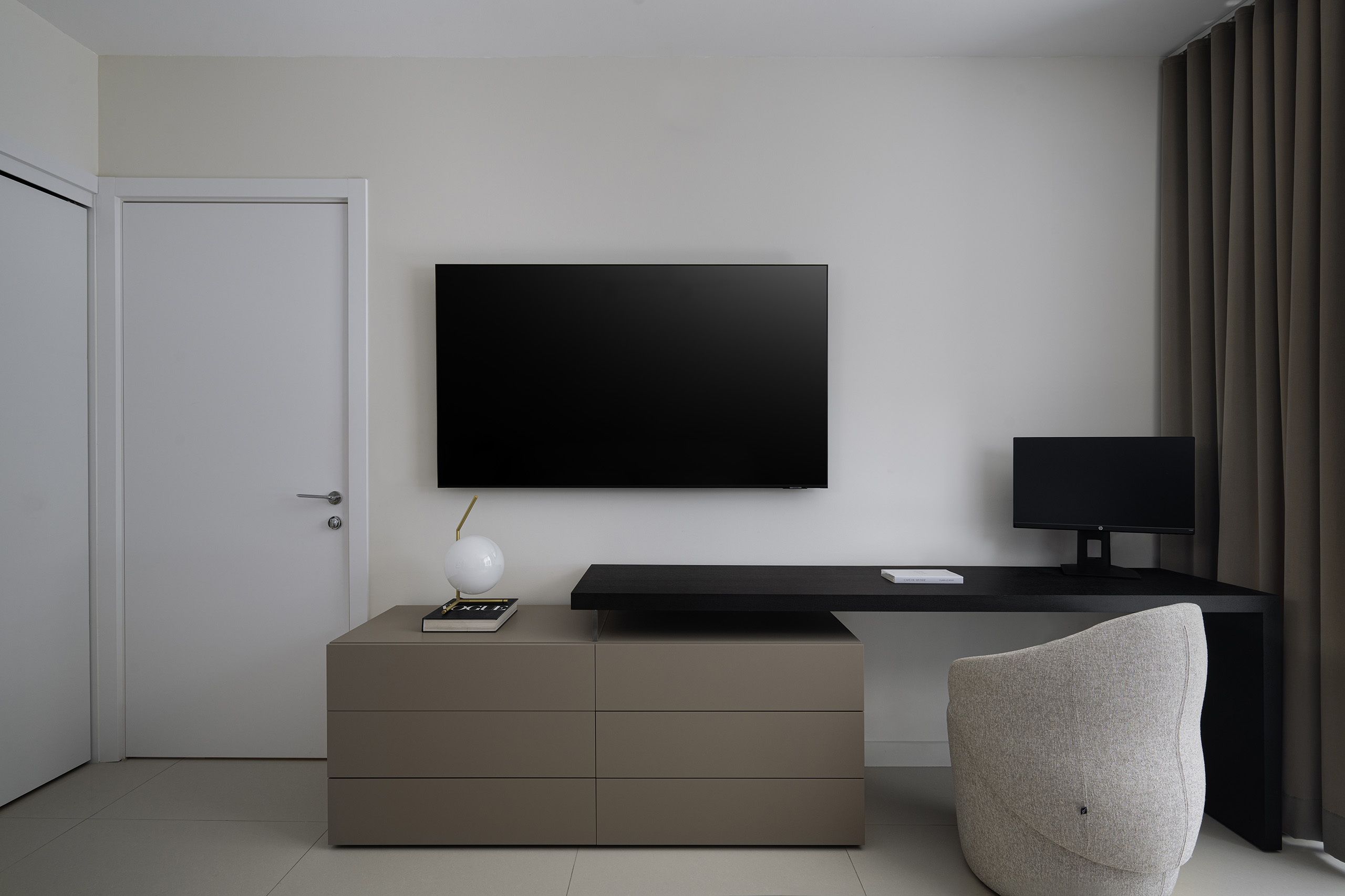 Home office in FM Apartment with custom desk, integrated storage, and upholstered task chair.