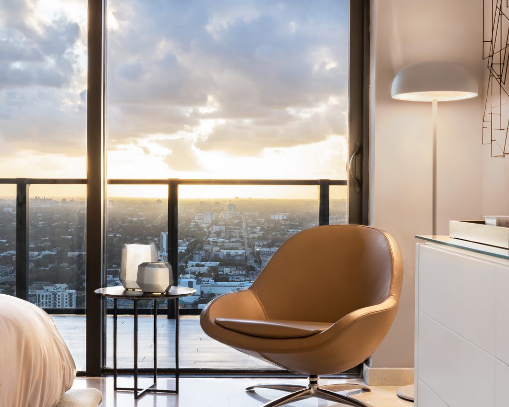 Leather swivel chair beside the window in the primary bedroom at RR Residence with sunset city views
