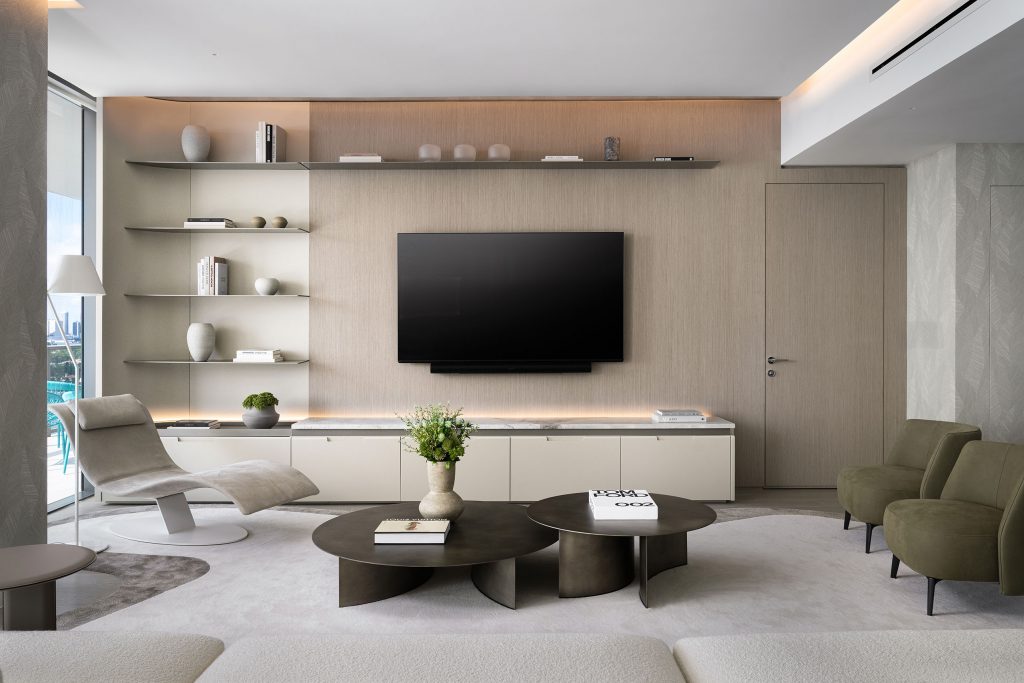 Full-length custom wood-paneled media wall with floating shelves, concealed flush door at PS Apartment Five Park Miami Beach